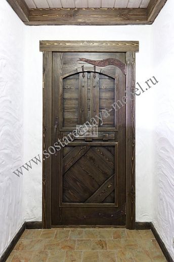 Входная дверь из дерева с коваными элементами – фото